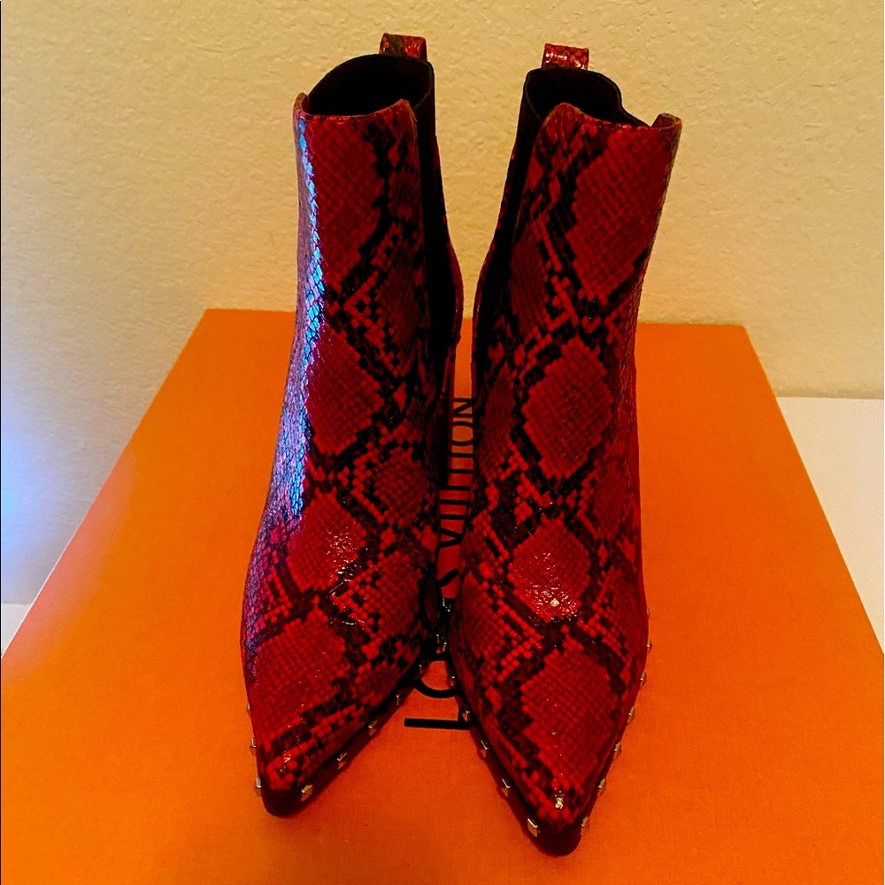 Stunning booties flaunts a dramatic toe, wild red/black snake print